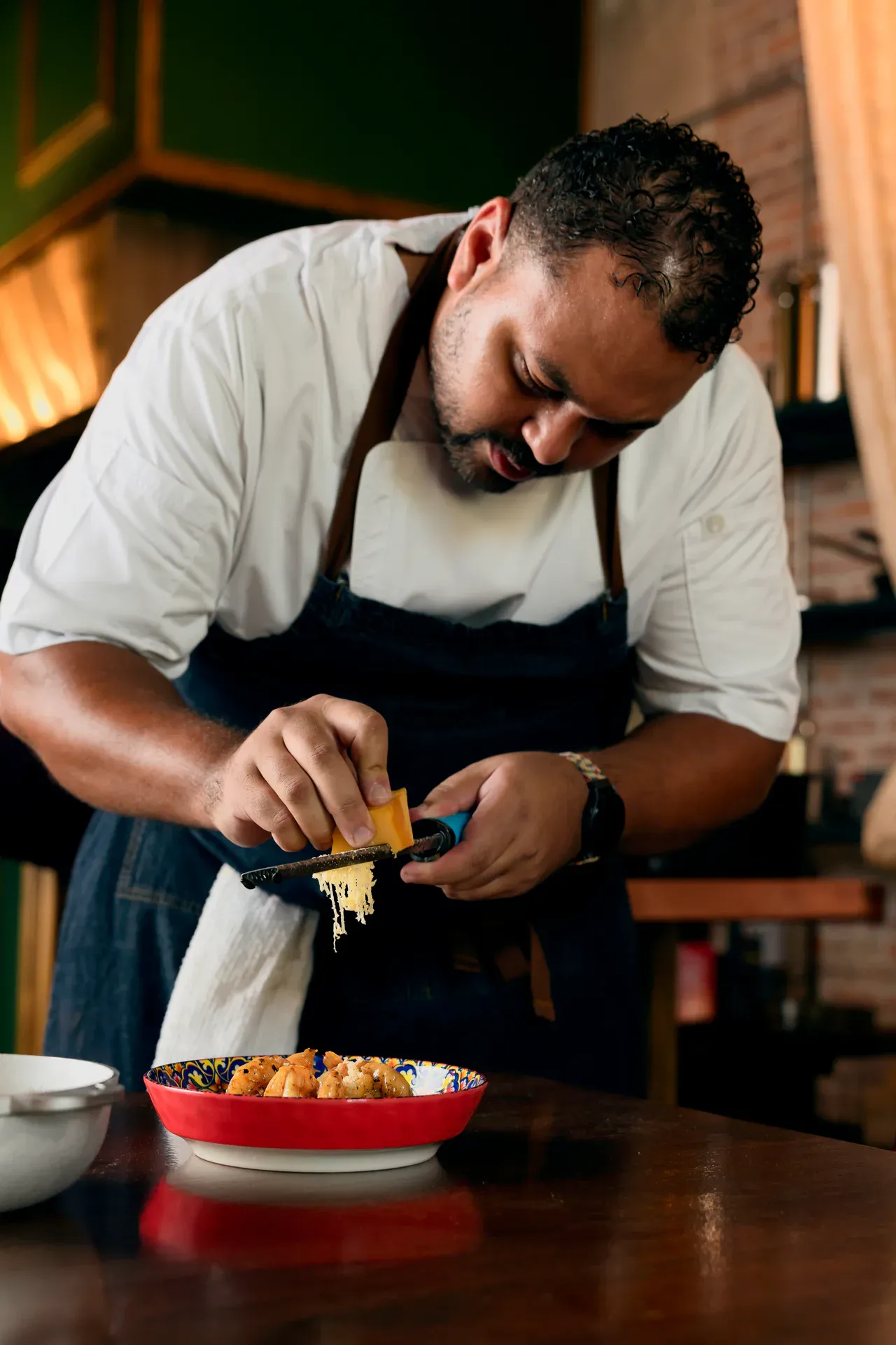 Chef finishing a dish with grated cheese at Petronita's, Jacksonville