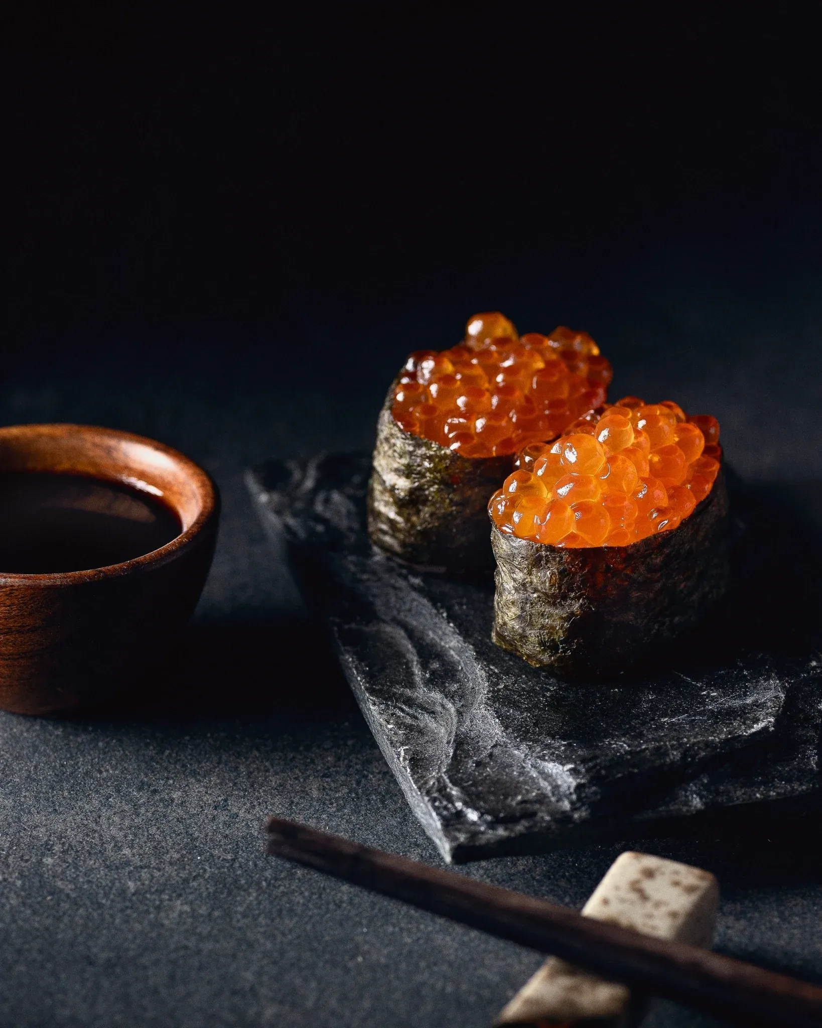 Salmon roe sushi in dramatic lighting